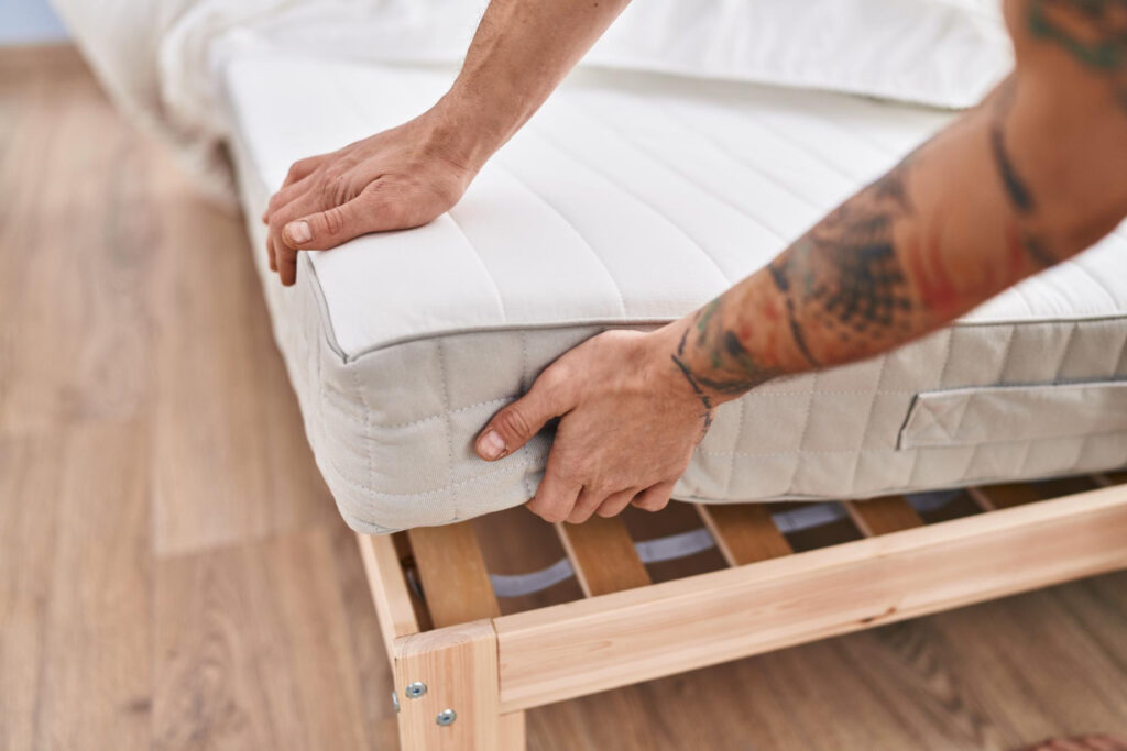 Young man holding a mattress